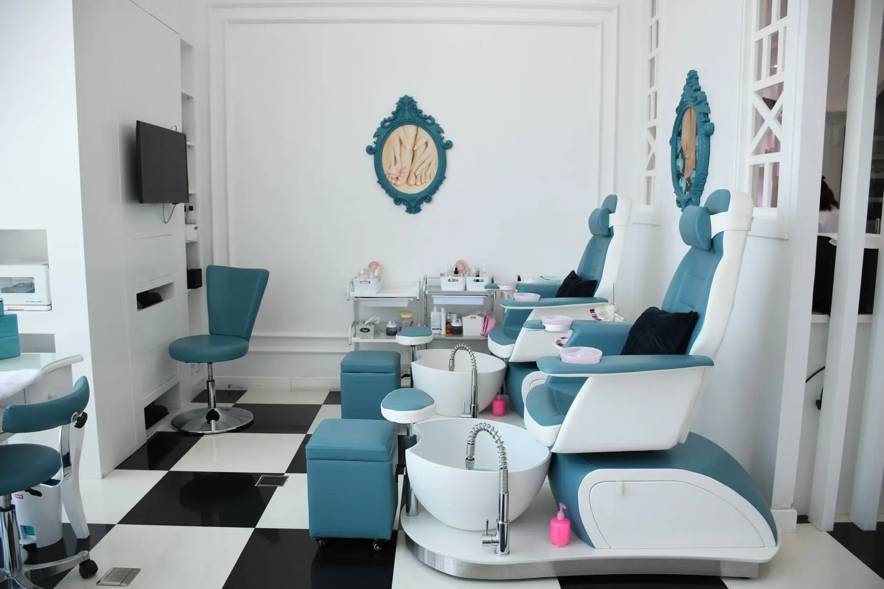 Fauteuils de pédicure bleus et blancs alignés devant leurs bassins, dans un institut lumineux.